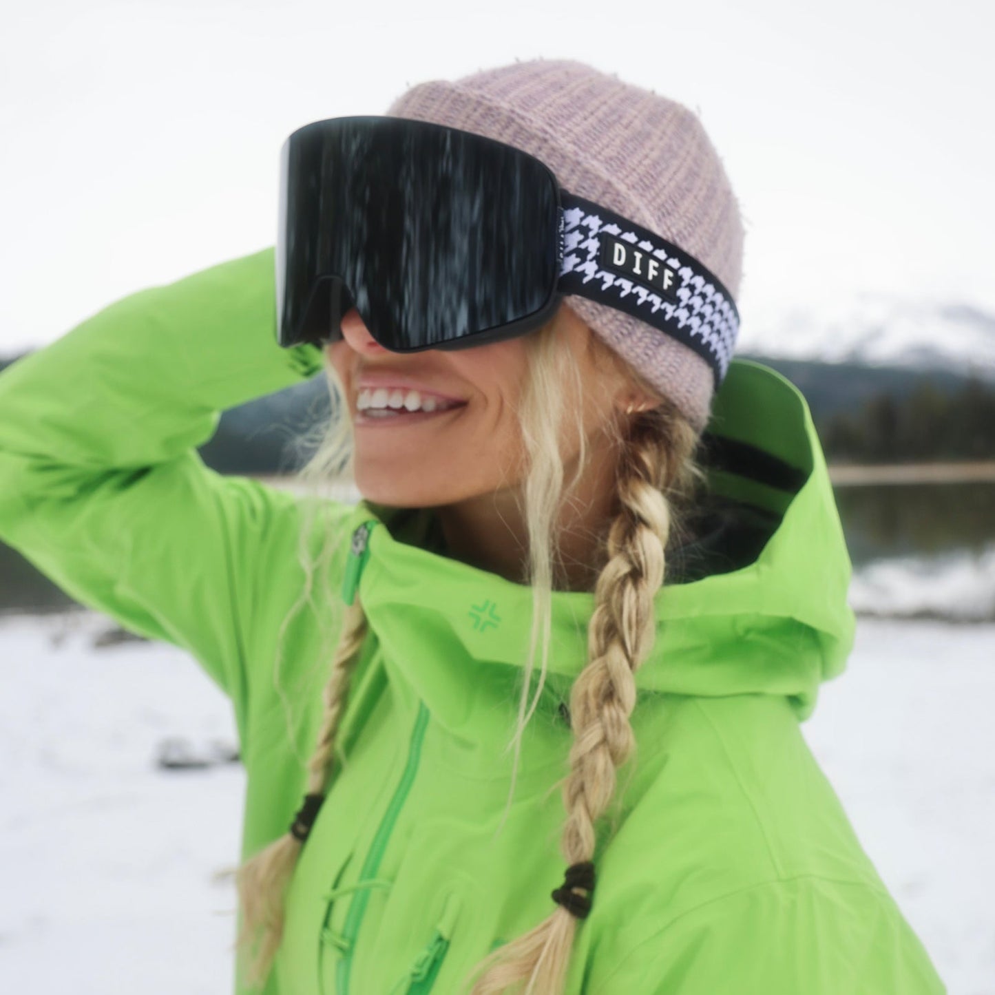 lifestyle - female wearing diff sport frost goggles houndstooth with silver mirror polarized lens on the slopes