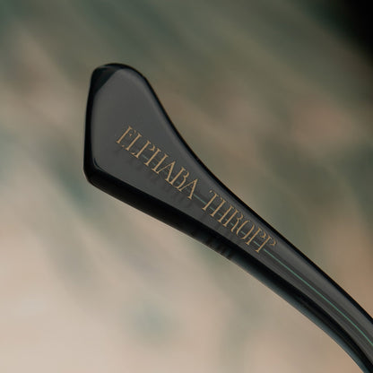 lifestyle - wicked x diff eyewear featuring the elphaba emerald square prescription glasses with a black green gradient frame detailed view of temple tip with Elphaba Thropp's name