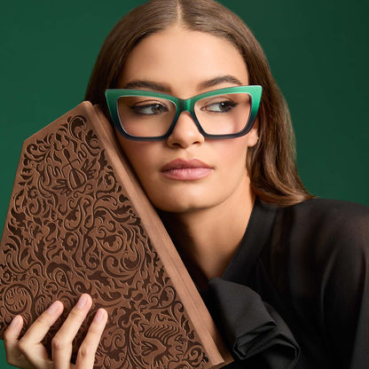 on model - female holding a spell book wearing wicked x diff eyewear featuring the elphaba emerald square prescription glasses with a black green gradient frame front view