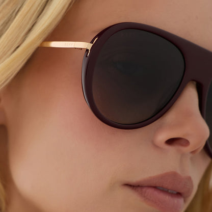 on model - blonde female wearing diff eyewear cleo oversized aviator sunglasses with a dark cherry lacquer red frame, gold temples and grey gradient polarized lenses detailed view