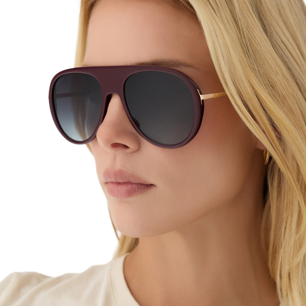 on model - blonde female wearing diff eyewear cleo oversized aviator sunglasses with a dark cherry lacquer red frame, gold temples and grey gradient polarized lenses angled view