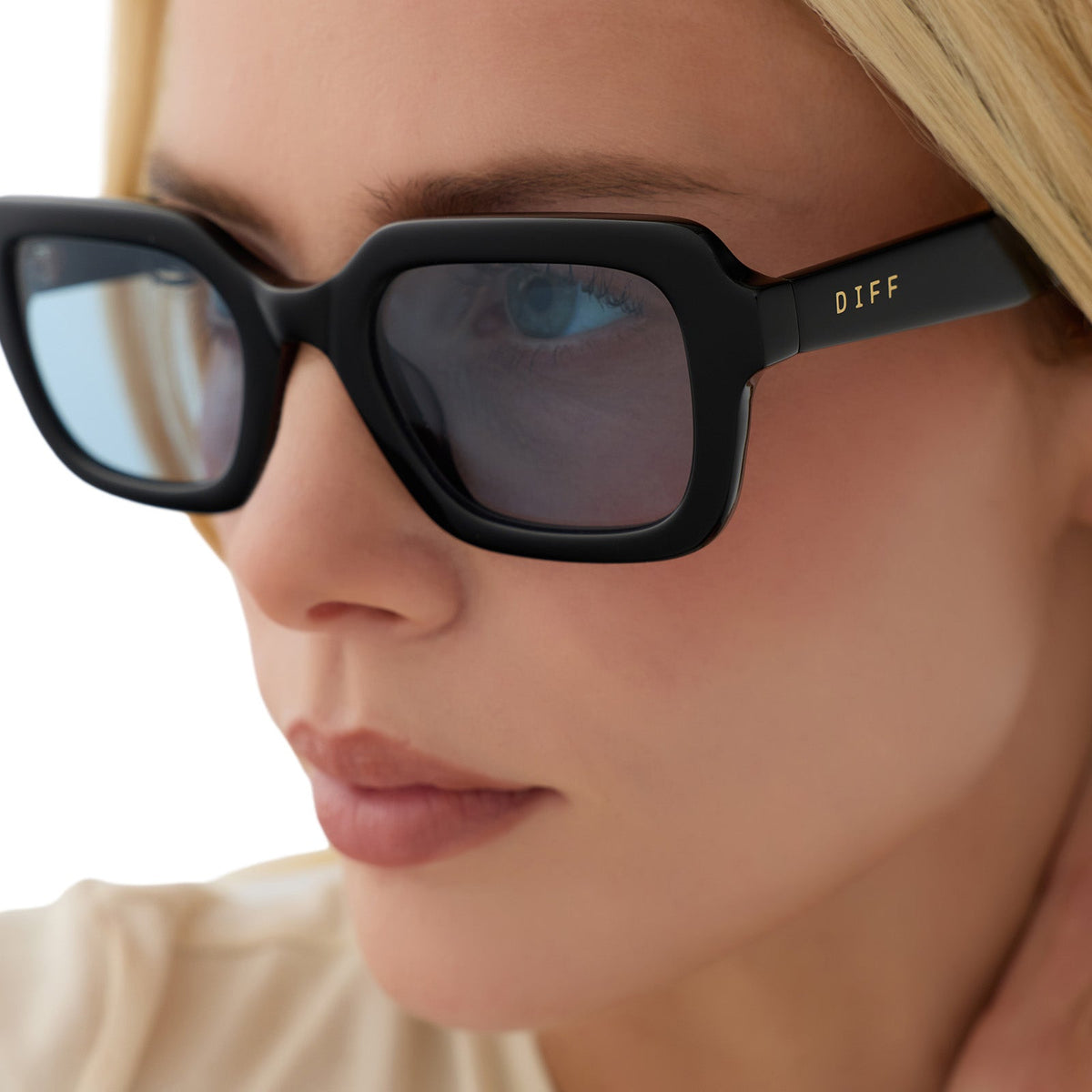on model - blonde female wearing diff eyewear gwynn square sunglasses with a black acetate frame and light blue tint lenses detailed view