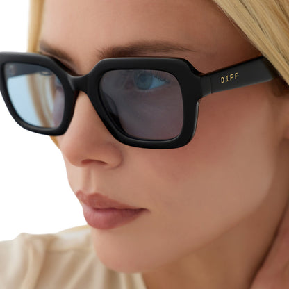 on model - blonde female wearing diff eyewear gwynn square sunglasses with a black acetate frame and light blue tint lenses detailed view