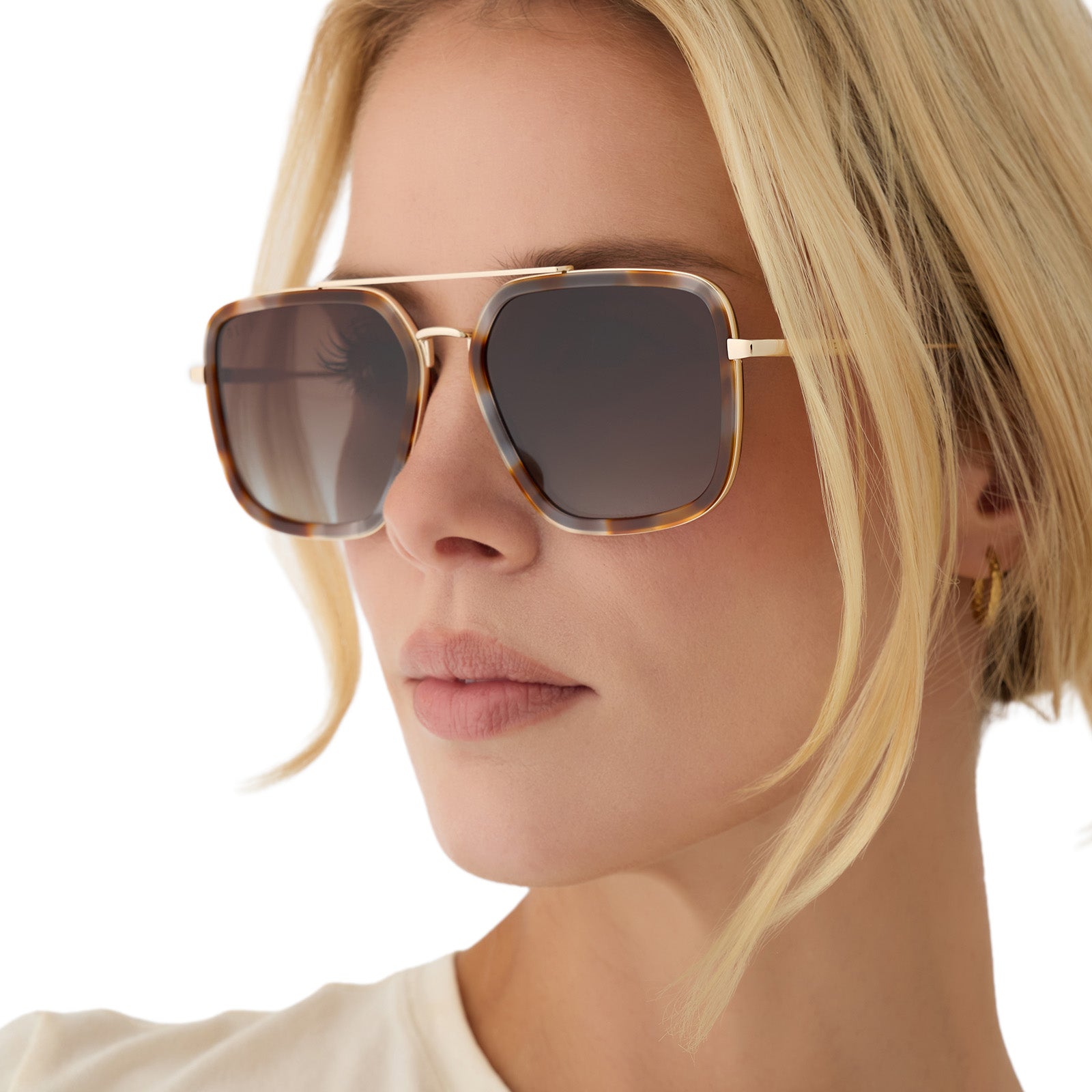 on model - blonde female wearing diff eyewear jordan navigator sunglasses with a dove tortoise brown frame, gold temples, and brown gradient polarized lenses side view