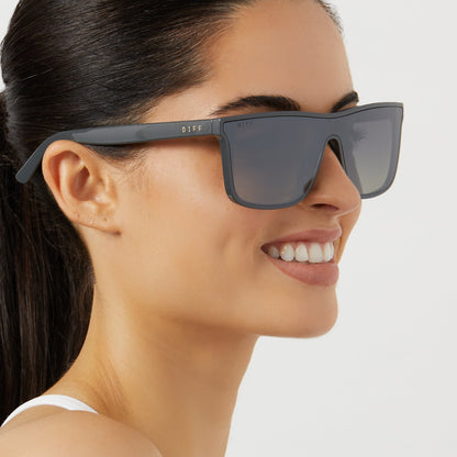 on model - female wearing diff sport flash square sunglasses with a slate grey frame and grey gradient with silver flash polarized lenses side view