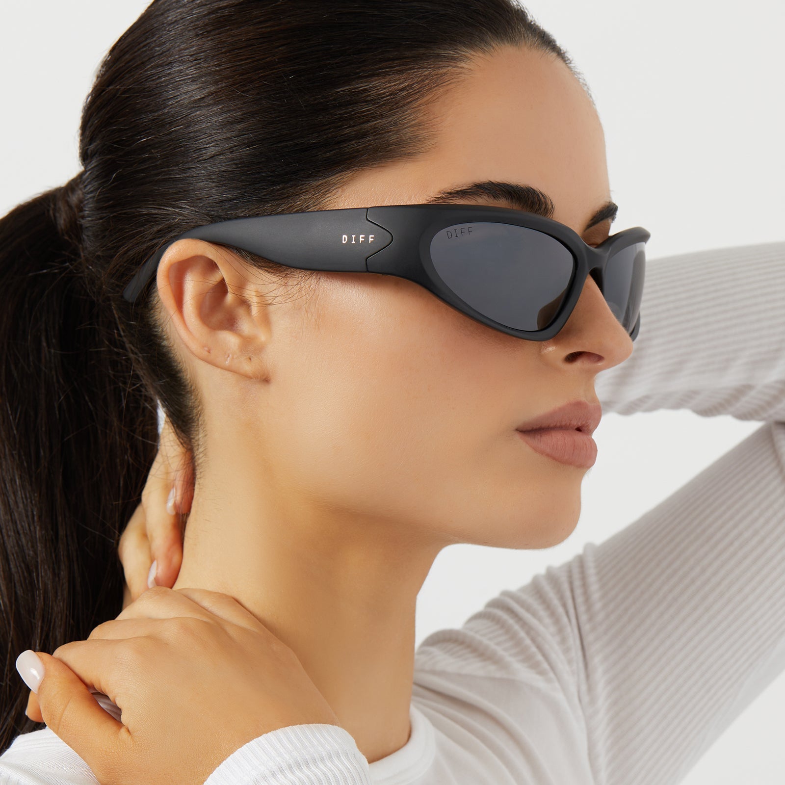 on model - female wearing diff sport side out wrap sunglasses with a matte black frame and grey with silver flash polarized lenses side view