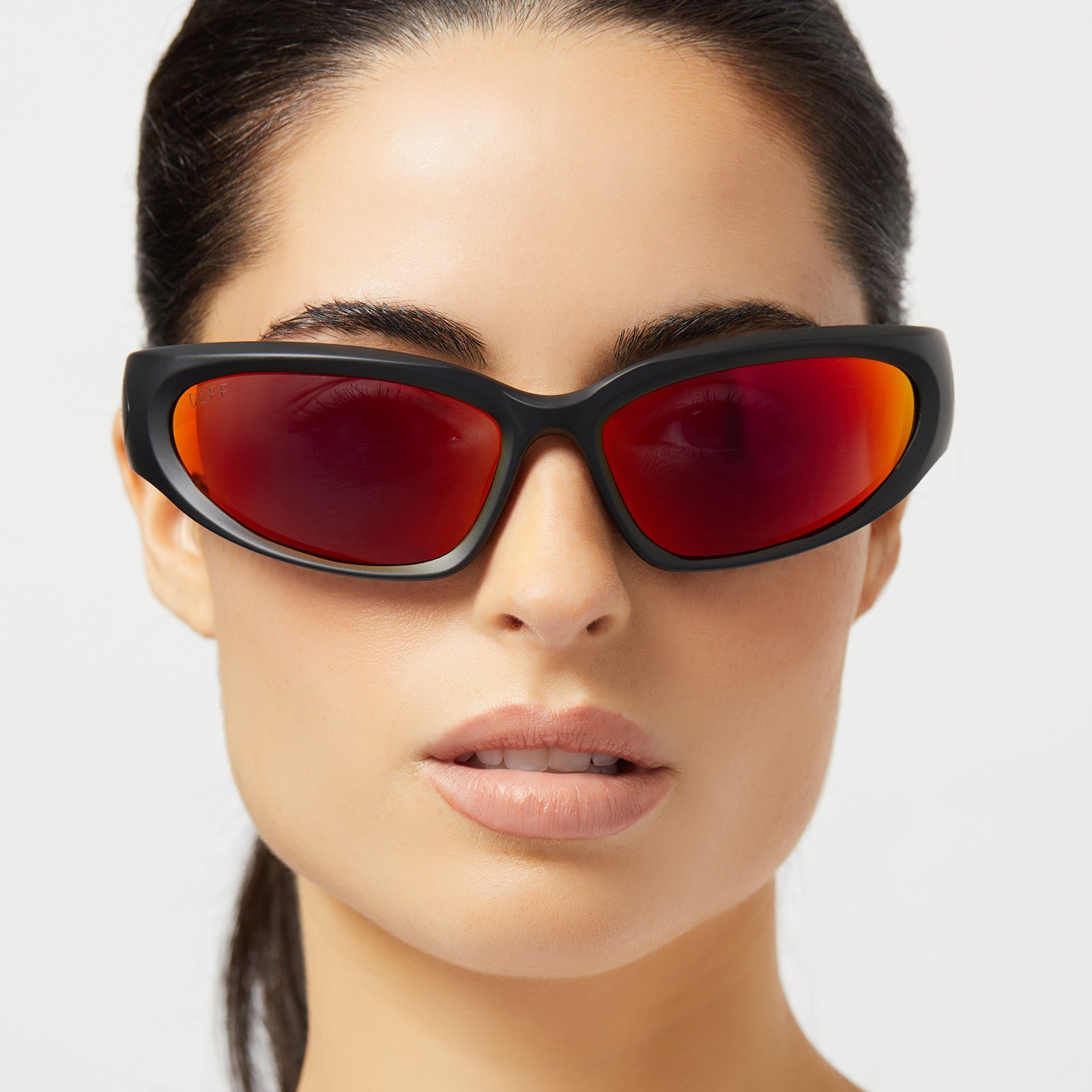 on model - female wearing diff sport side out wrap sunglasses with a matte black frame and sunset mirror polarized lenses front view