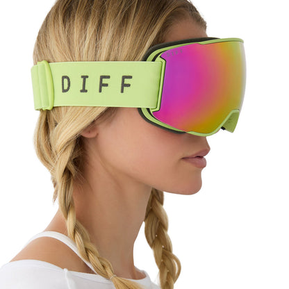 on model - female wearing lifestyle - female wearing diff sport alpine goggles in lime green with hot pink mirror polarized lens side view