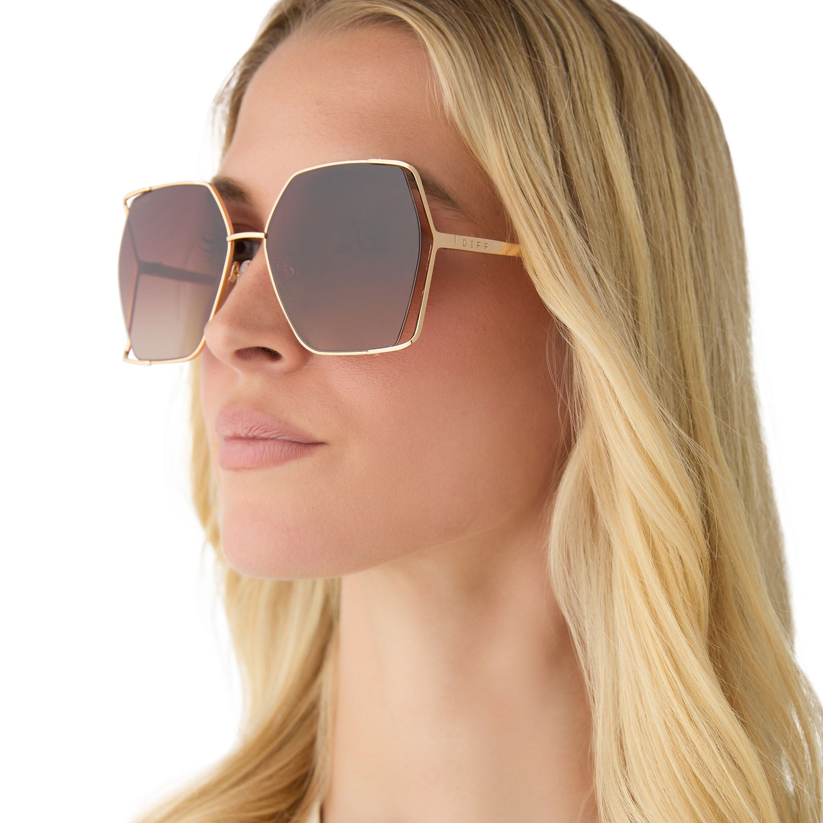 on model - female wearing diff eyewear featuring the donna iv square sunglasses with a gold frame and brown gradient lenses side view