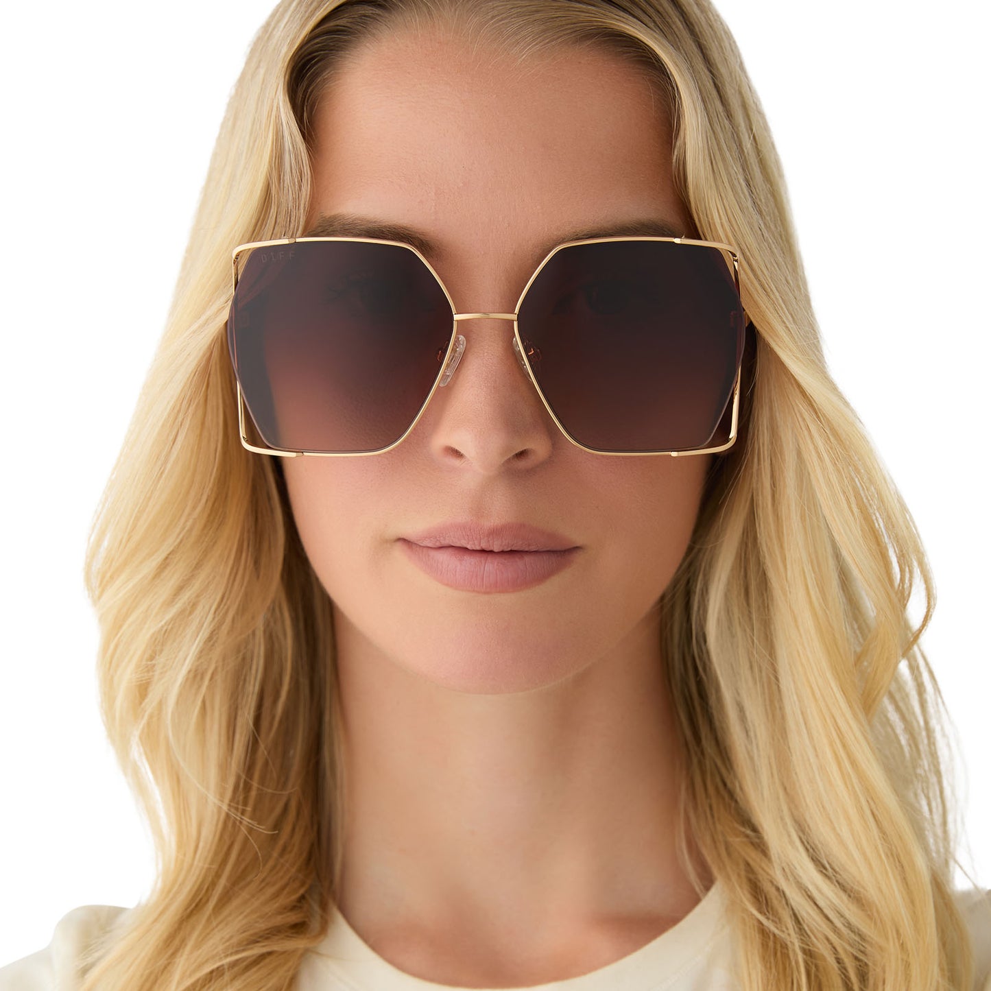 on model - female wearing diff eyewear featuring the donna iv square sunglasses with a gold frame and brown gradient lenses front view