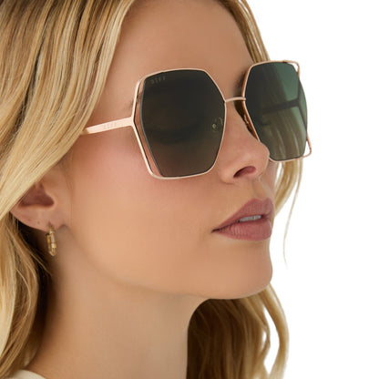 on model - female wearing diff eyewear featuring the donna iv square sunglasses with a brushed champagne frame and cool matcha gradient polarized lenses angled view