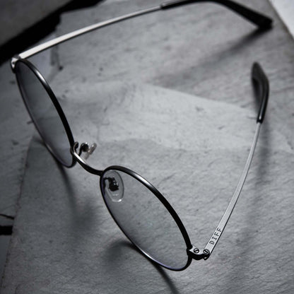 Harry Potter x DIFF Harry Potter glasses lying open on top of black broken stone