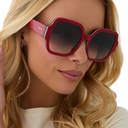 on model - female wearing clueless x diff eyewear featuring the dionne square sunglasses with a red frame and grey gradient lenses angled view