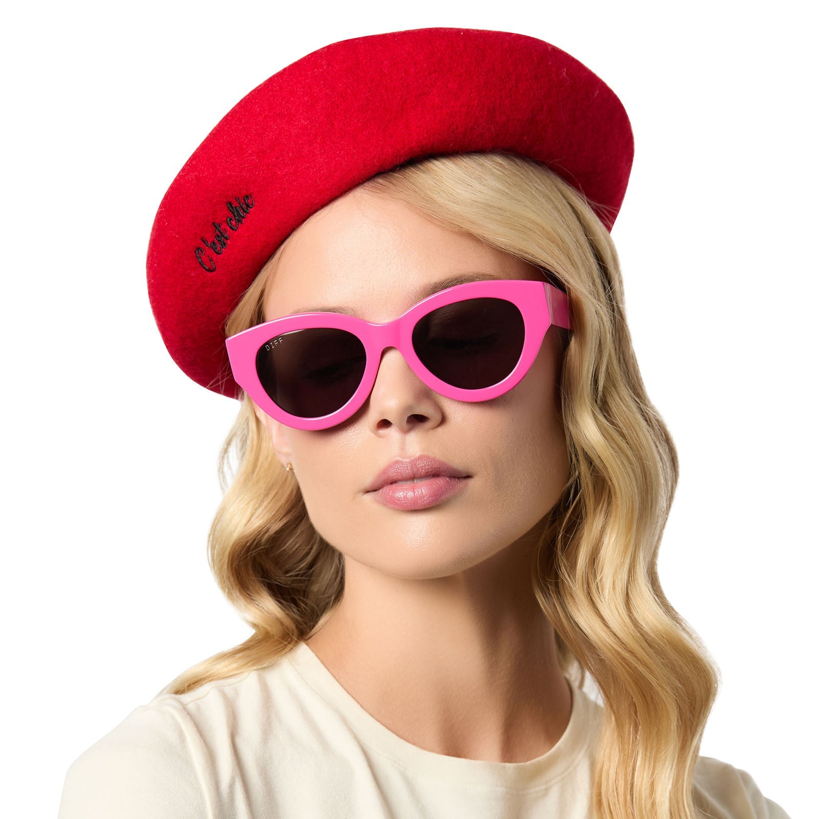 on model - female wearing diff eyewear x emily in paris featuring the emily pink cat eye sunglasses and free with purchase red beret hat