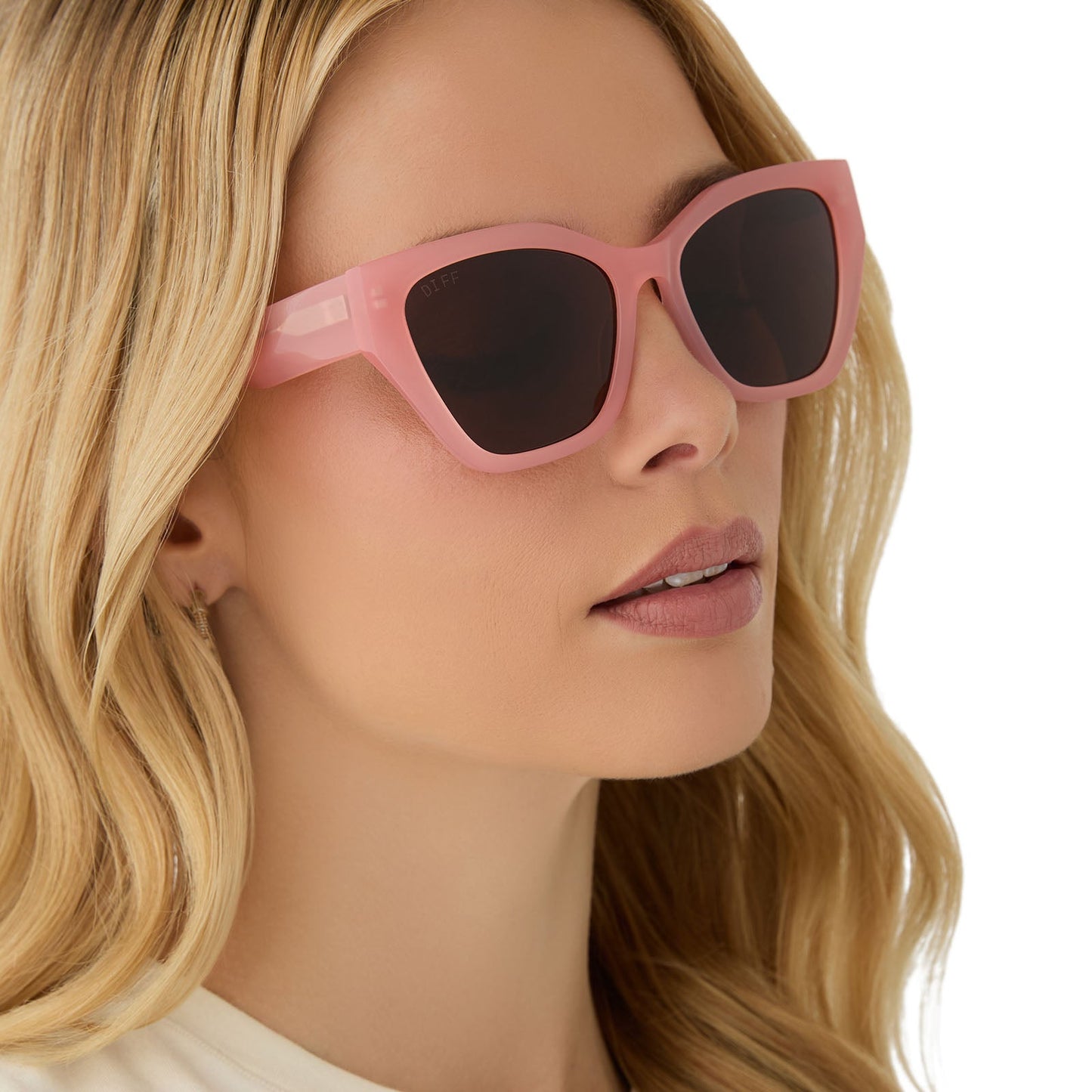 on model - female wearing diff eyewear featuring the evie cat eye sunglasses with a peach frame and brown polarized lenses angled view