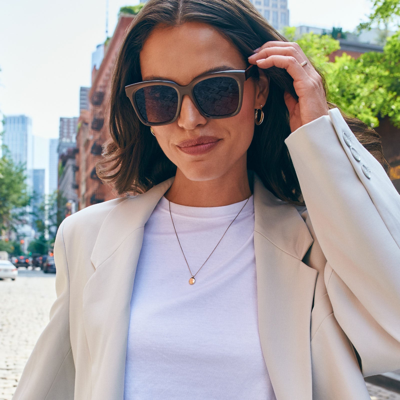 lifestyle - female wearing diff eyewear featuring the meredith square sunglasses with a moscow mule frame and brown gradient gold flash polarized lenses front view