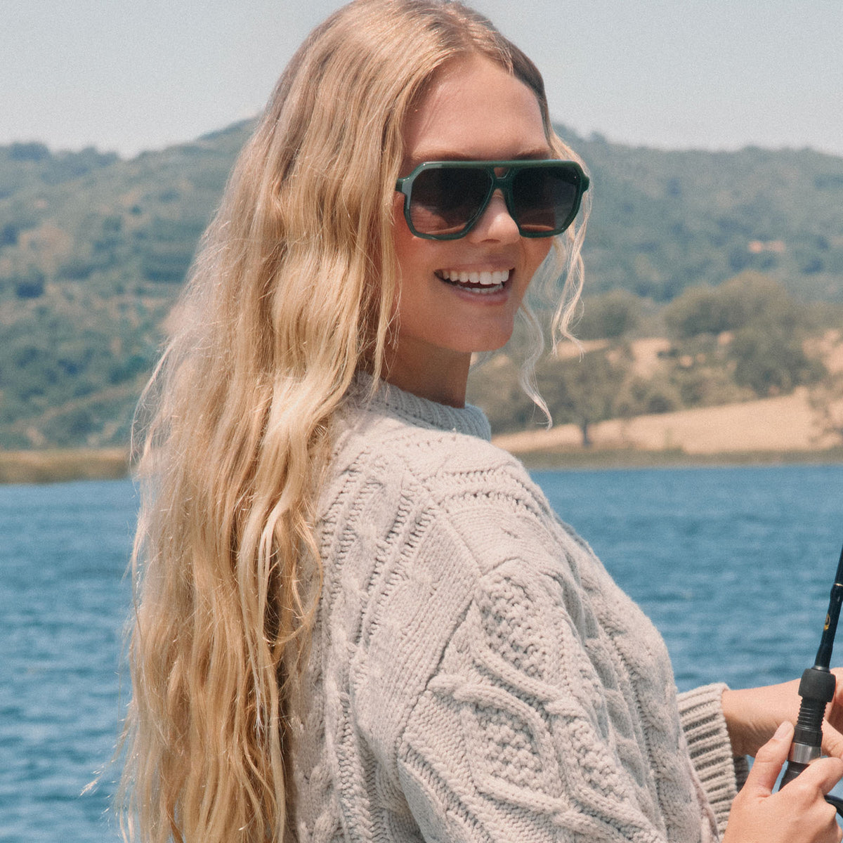 lifestyle - blonde female on a lake fishing wearing diff eyewear cameron navigator sunglasses in a fairway green acetate frame with grey gradient polarized lenses front view