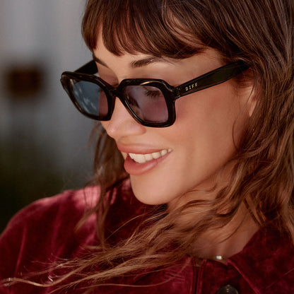 lifestyle - female wearing diff eyewear gwynn square sunglasses with a black acetate frame and light blue tint lenses side view