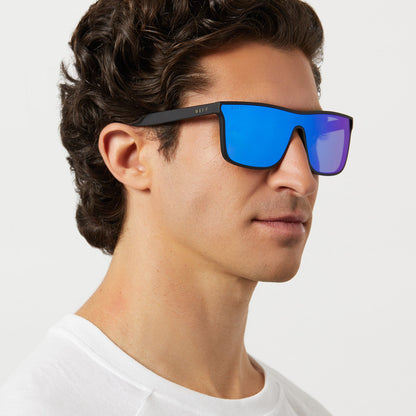 on model - male wearing diff sport flash square sunglasses with a matte black frame and blue mirror polarized lenses