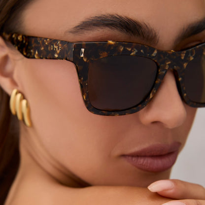 on model - female wearing diff eyewear featuring the bradley cat eye sunglasses with a glitter tortoise frame and brown polarized lenses angled view