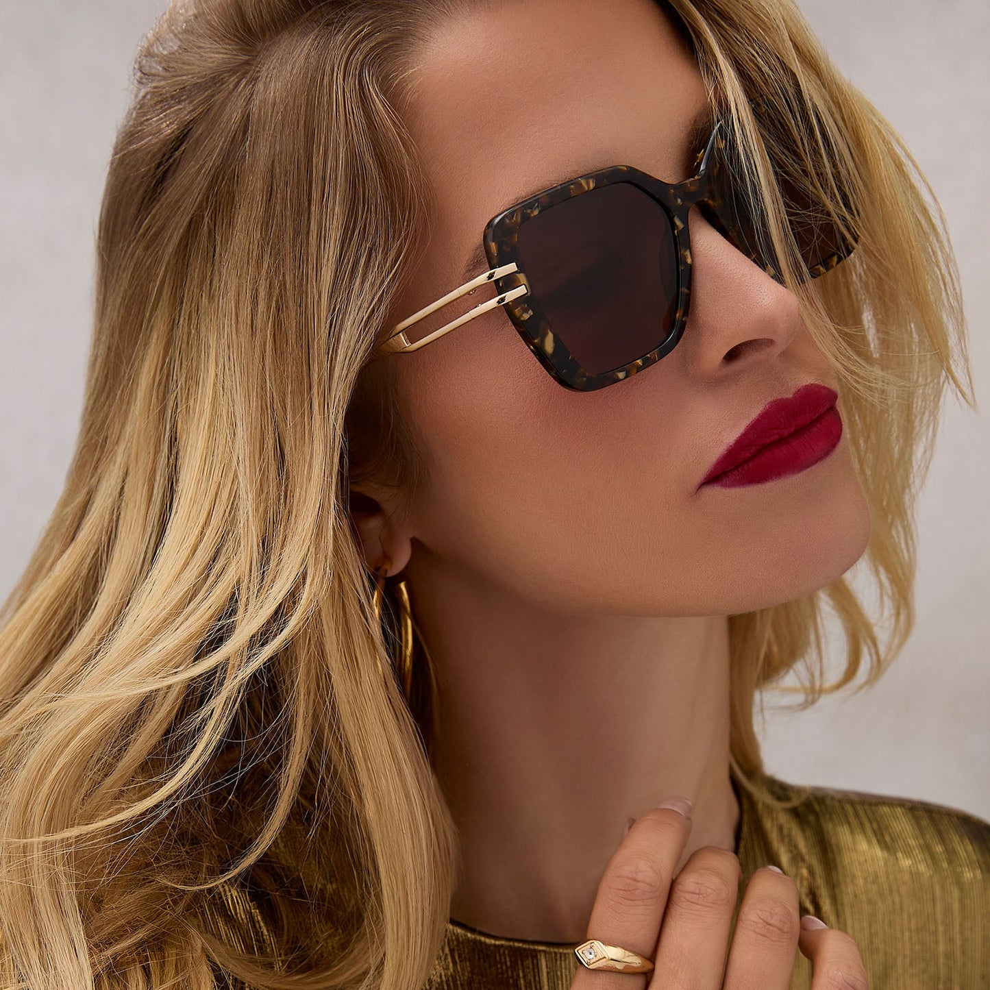 on model - female wearing diff eyewear featuring the dasha square sunglasses with a glitter gold tortoise frame and brown lenses angled view