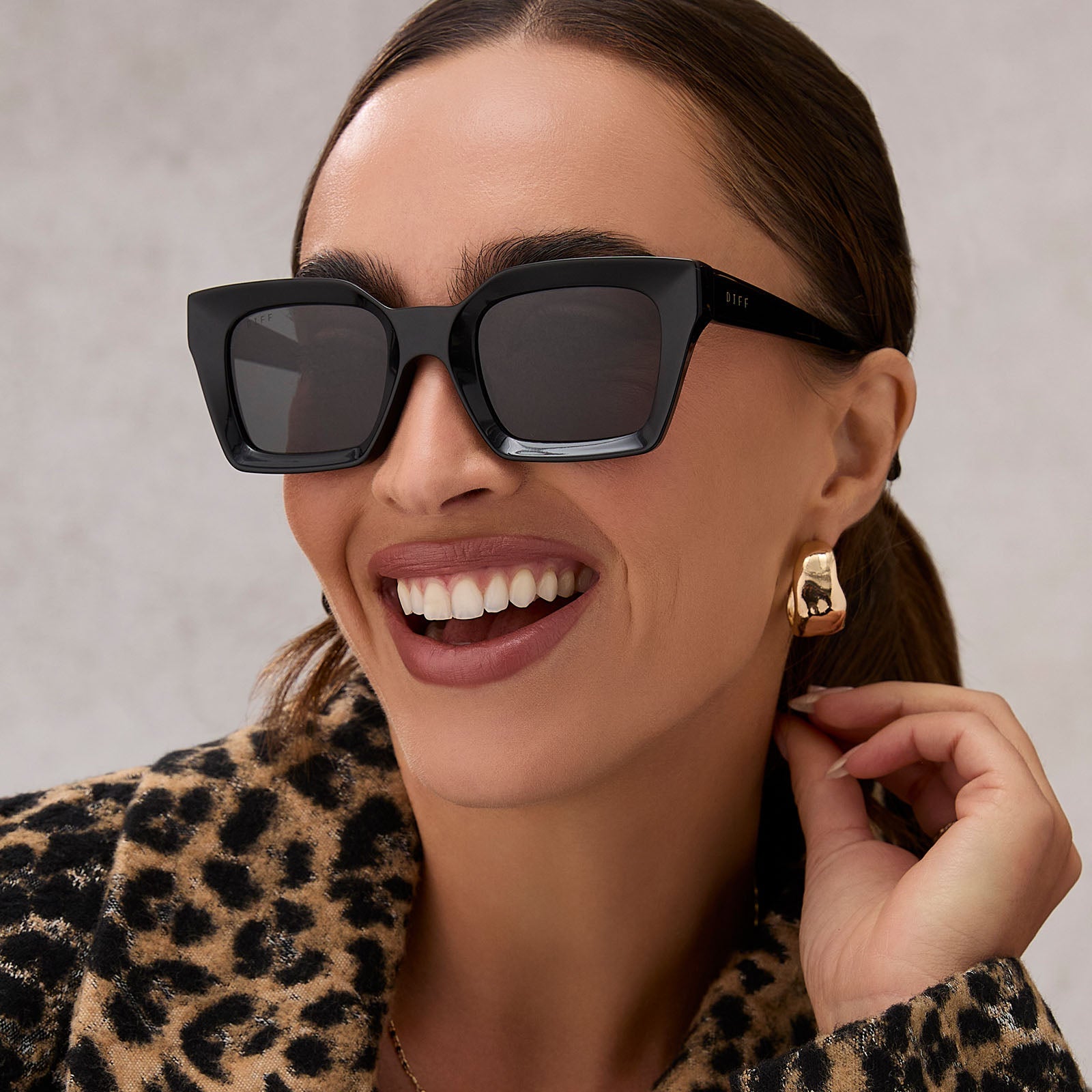 on model - female wearing diff eyewear featuring the greer square sunglasses with a black frame and grey lenses angled view