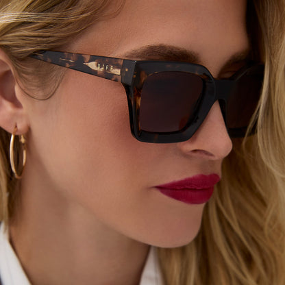 on model - female wearing diff eyewear featuring the greer square sunglasses with a espresso tortoise frame and brown gradient lenses angled view