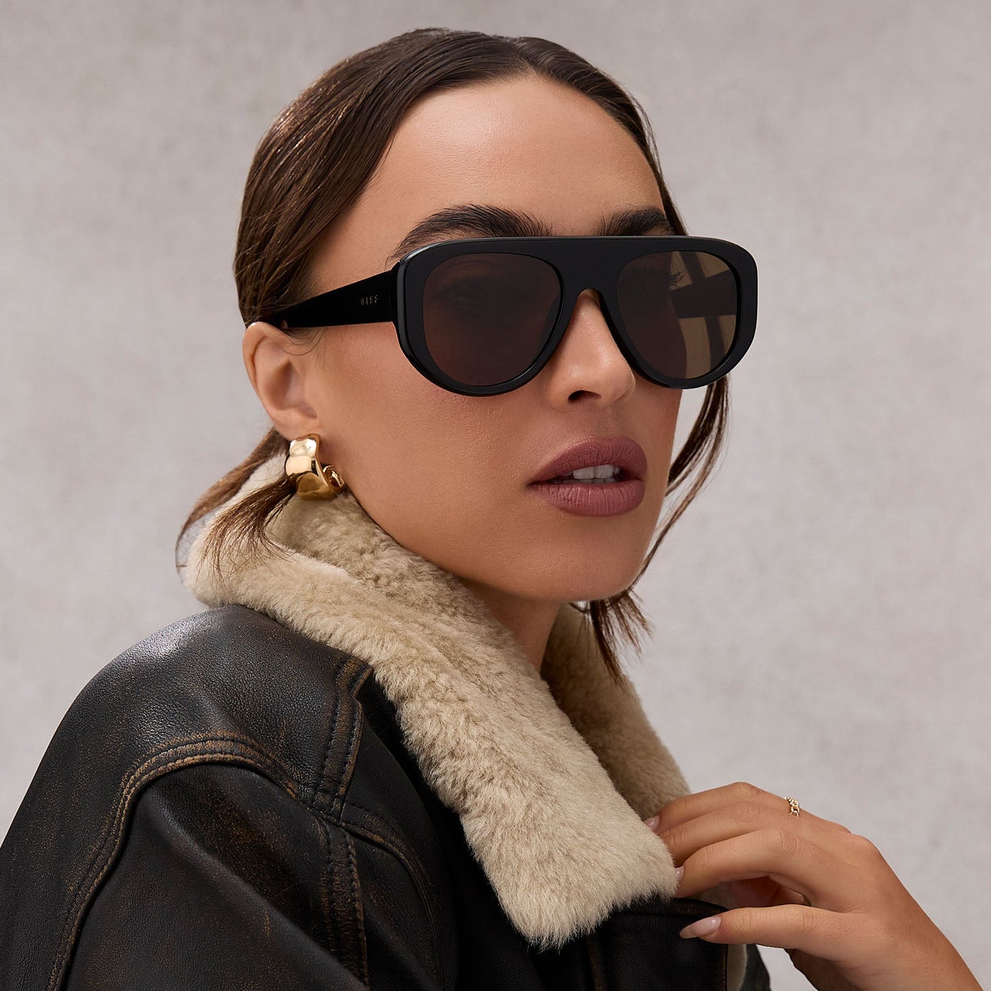 on model - female wearing diff eyewear featuring the morgan shield sunglasses with a black frame and brown lenses front view