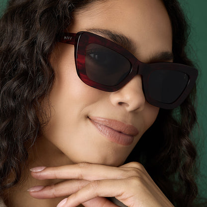 on model - female wearing diff eyewear featuring the adriana cateye sunglasses with a rich red tortoise frame and grey lenses front view