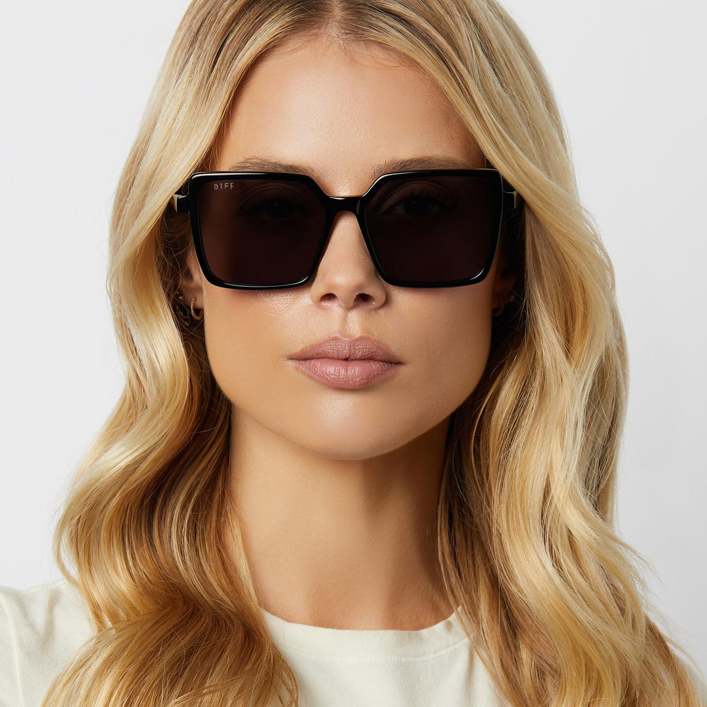 on model -  blonde female wearing diff eyewear featuring the esme square sunglasses with a black frame and grey polarized lenses front view