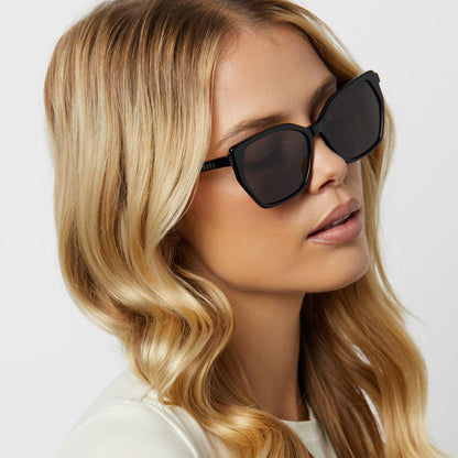 on model - blonde female wearing diff eyewear featuring the vera cateye sunglasses with a black frame and grey lenses angled view