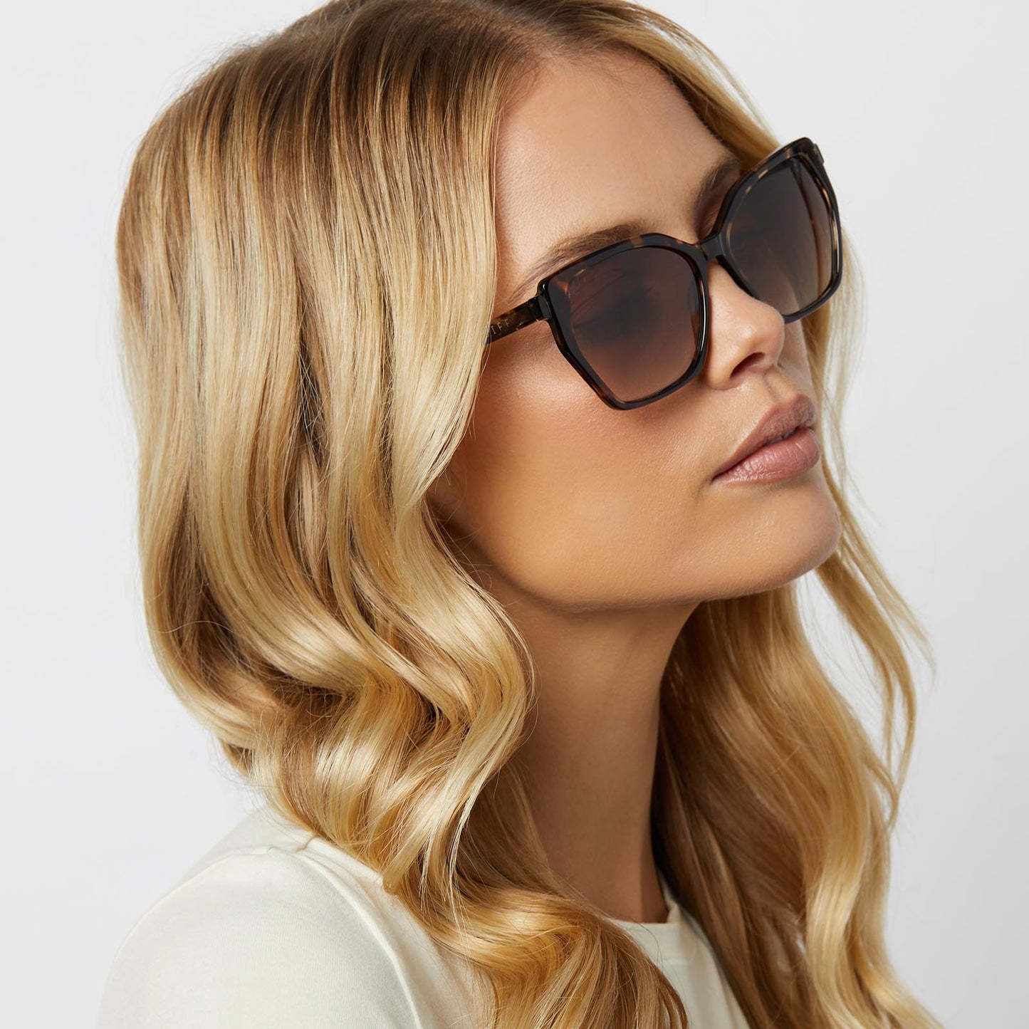 on model - blonde female wearing diff eyewear featuring the vera cateye sunglasses with a espresso tortoise frame and brown gradient polarized lenses angled view