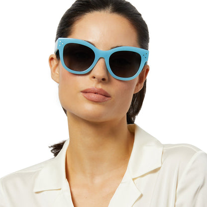 on model - female wearing iconica x diff eyewear eva cat eye sunglasses with a parasido blue frame and grey gradient polarized lenses front view