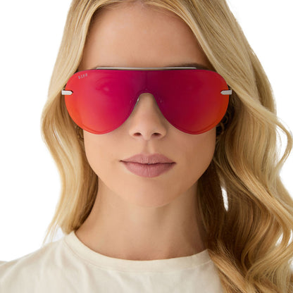 on model - female wearing diff eyewear featuring the imani shield sunglasses with a gunmetal frame and red hot summer mirror lenses front view