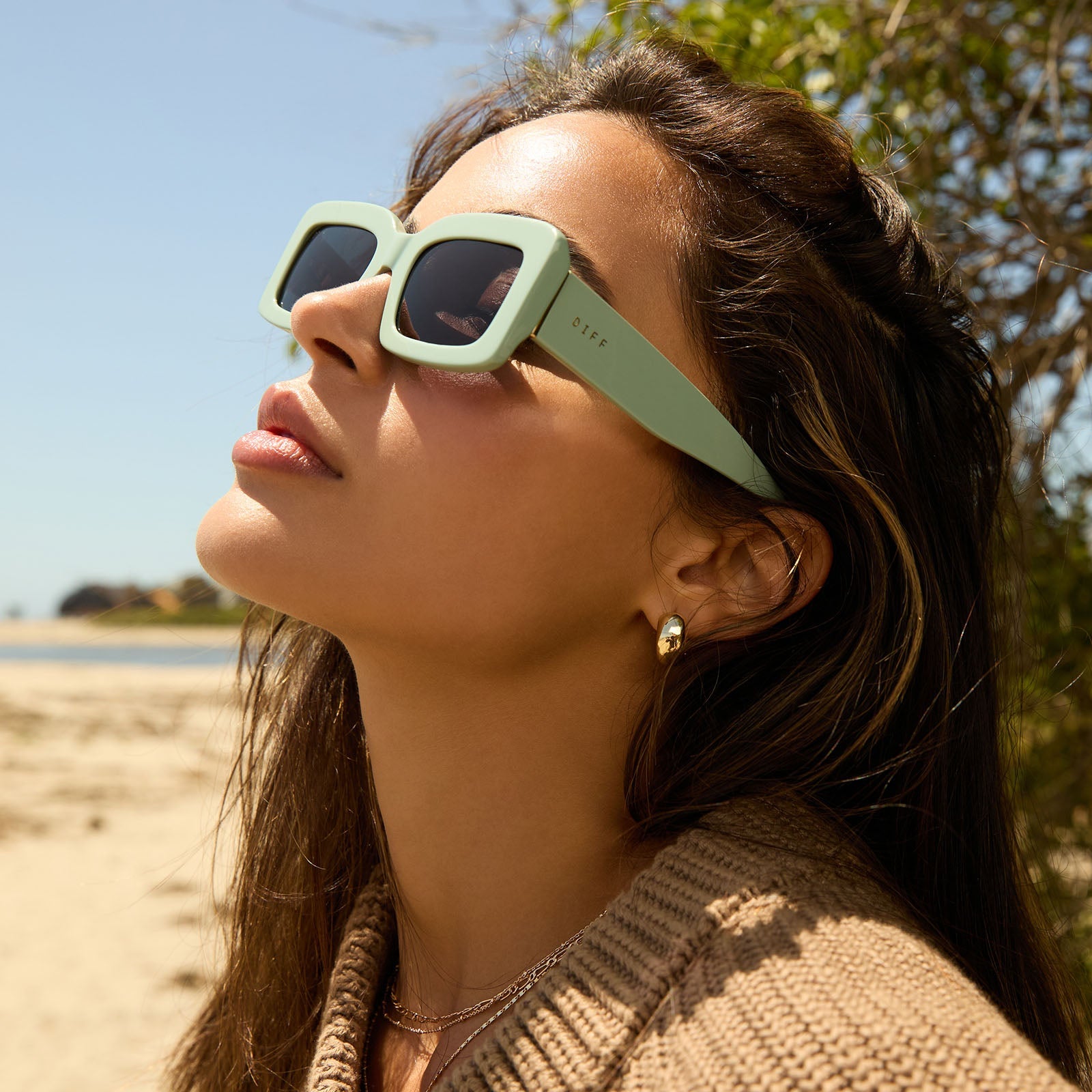 on model - female while at the beach wearing diff eyewear featuring the indy rectangle sunglasses with a steel teal frame and grey polarized lenses side view