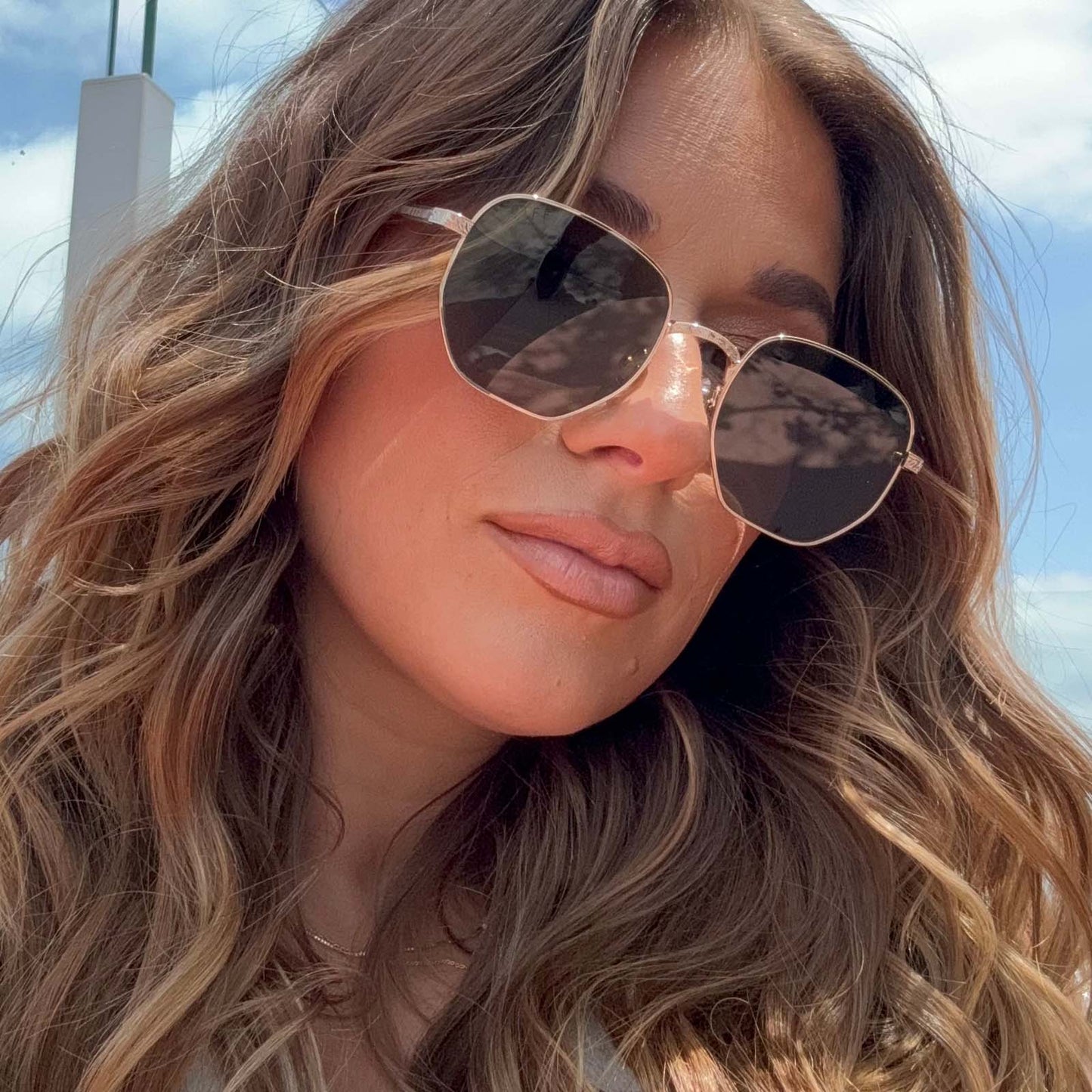 lifestyle - jessie james decker wearing jessie james decker x diff eyewear aster sunglasses with a gold metal frame and g15 polarized lenses front view