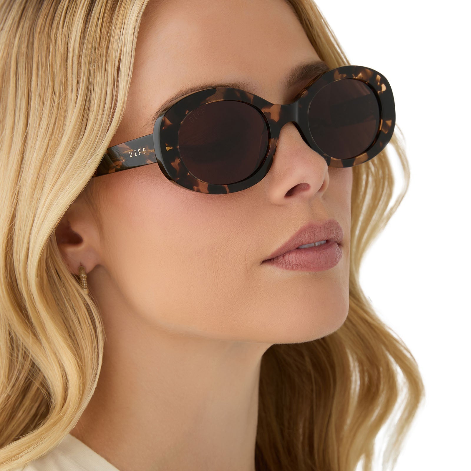 on model - female wearing diff eyewear featuring the lainey oval sunglasses with a espresso tortoise frame and brown lenses angled view