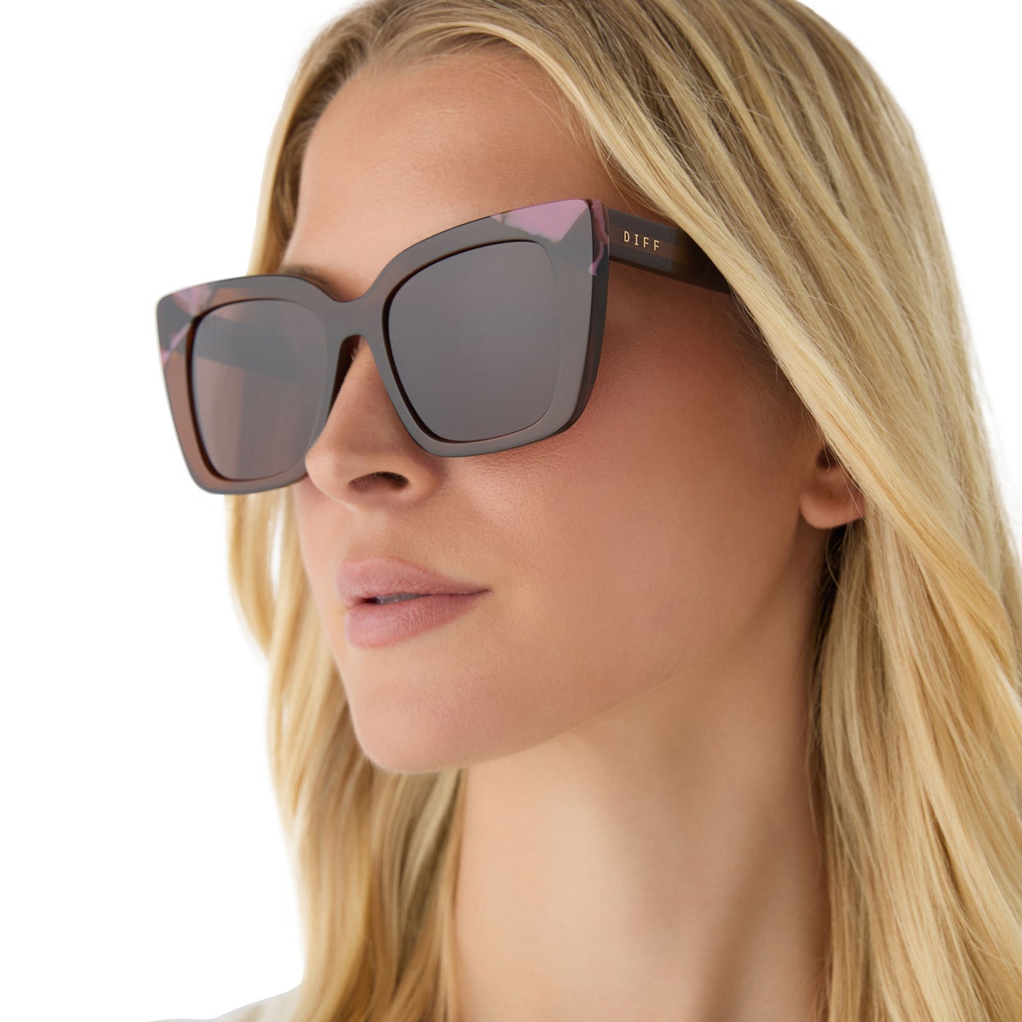on model - female wearing diff eyewear featuring the lizzy cat eye sunglasses with a whiskey + torino tortoise frame and brown lenses angled view