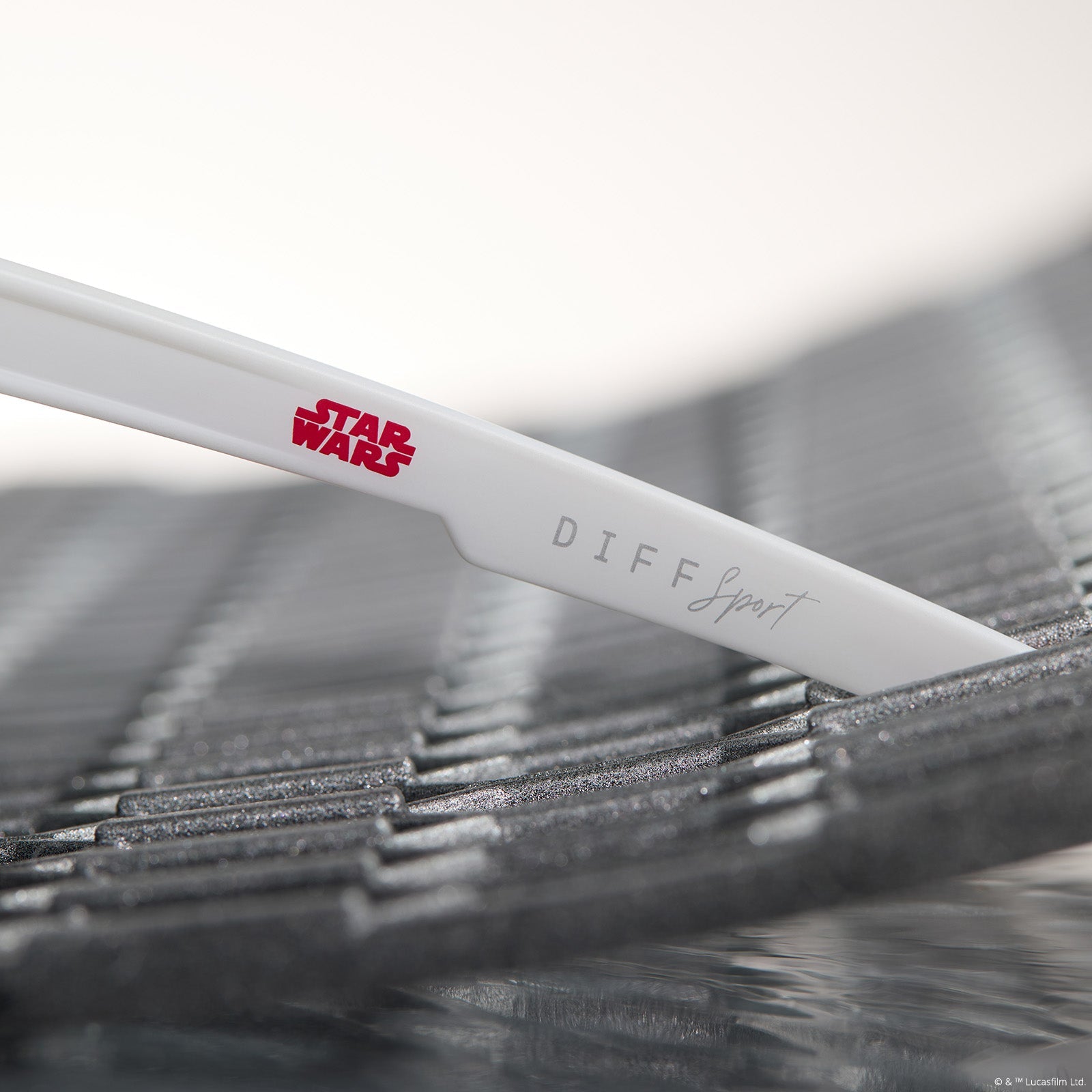 lifestyle - star wars™ x diff sport featuring the luke x-wing™ 2.0 shield sunglasses with a white frame and red orange fire mirror polarized lenses detailed view of temple leg