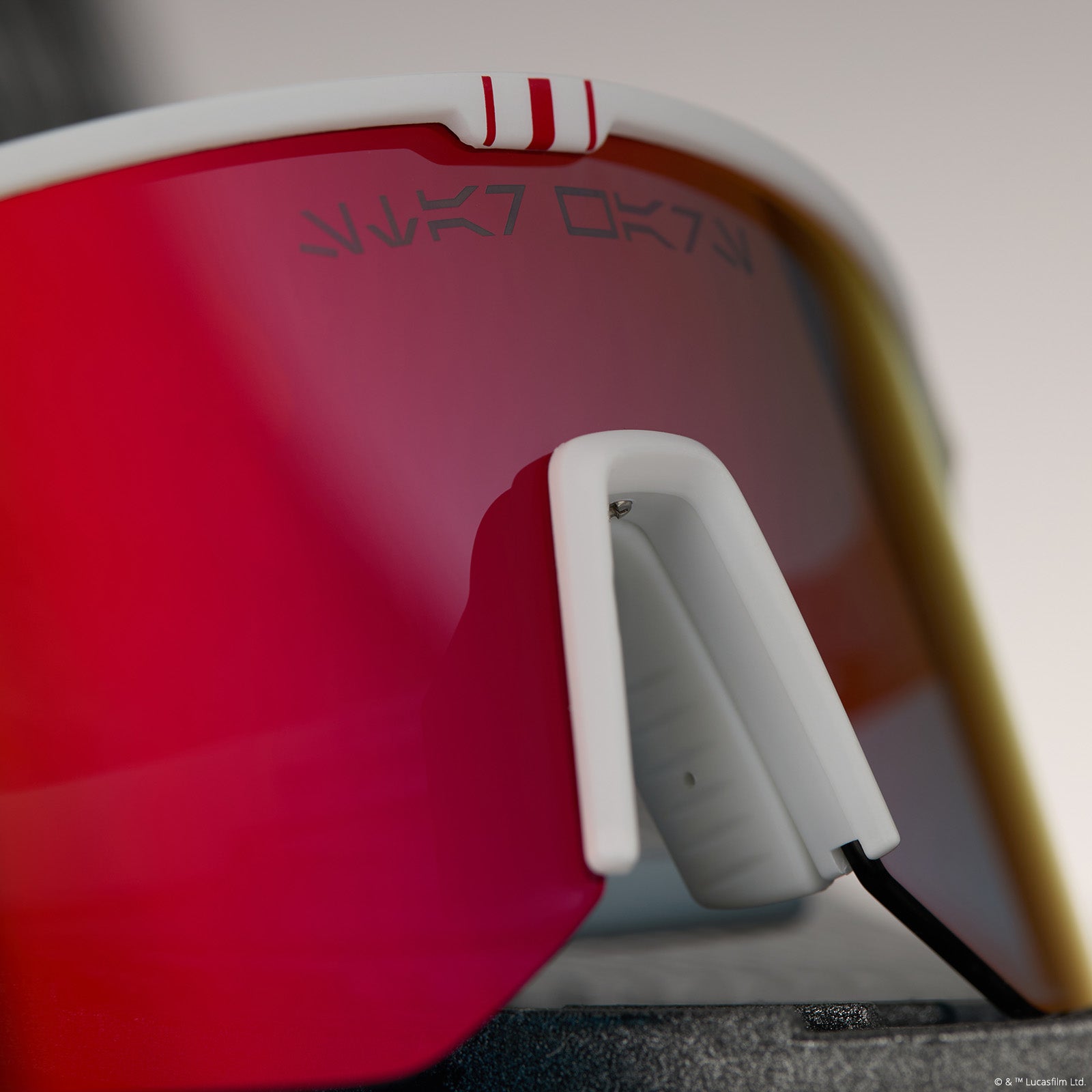 lifestyle - star wars™ x diff sport featuring the luke x-wing™ 2.0 shield sunglasses with a white frame and red orange fire mirror polarized lenses detailed view of bridge writting