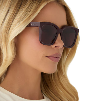 on model - female wearing diff eyewear featuring the meredith square sunglasses with a dark cherry lacquer frame and dark cherry polarized lenses angled view