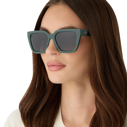 on model - female wearing diff eyewear featuring the amara square sunglasses with a fairway green acetate frame and grey gradient polarized lenses angled view