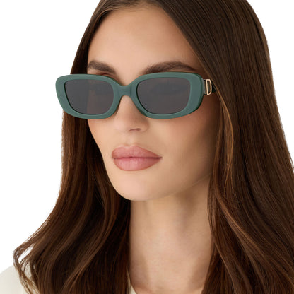 on model - female wearing diff eyewear featuring the daphne rectangle sunglasses with a fairway green acetate frame and grey lenses angled view