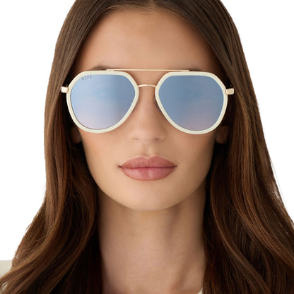 on model - female wearing diff eyewear featuring the joey round sunglasses with a courtside ivory & gold metal frame with blue slate gradient flash lenses front view
