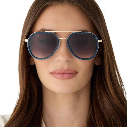 on model - female wearing diff eyewear featuring the joey round sunglasses with a clubhouse blue & brushed gold metal frame with grey gradient lenses front view