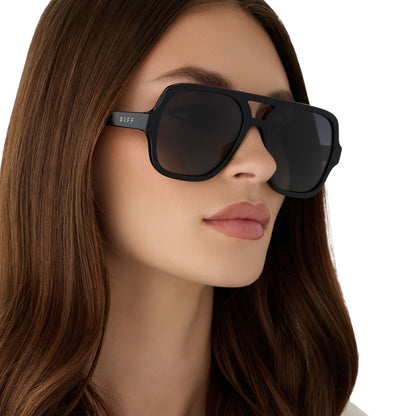 on model - female wearing diff eyewear featuring the layton navigator sunglasses with a black acetate frame and grey gradient polarized lenses angled view