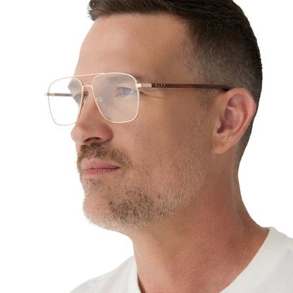 on model - male wearing yellowstone x diff eyewear featuring the rip wheeler navigator prescription glasses with a gold frame side view