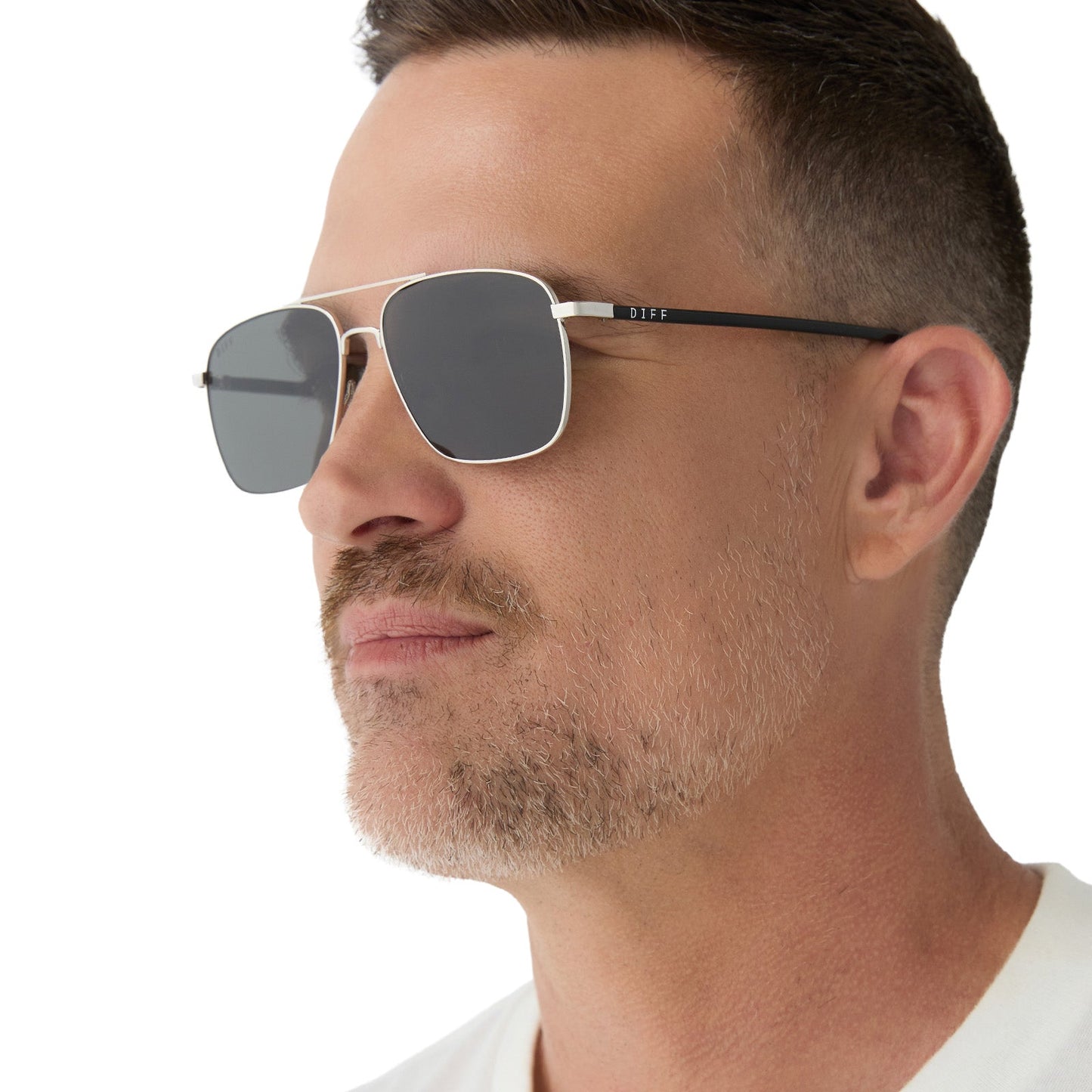 on model - male wearing yellowstone x diff eyewear featuring the rip wheeler navigator sunglasses with a silver frame and grey polarized lenses angled view