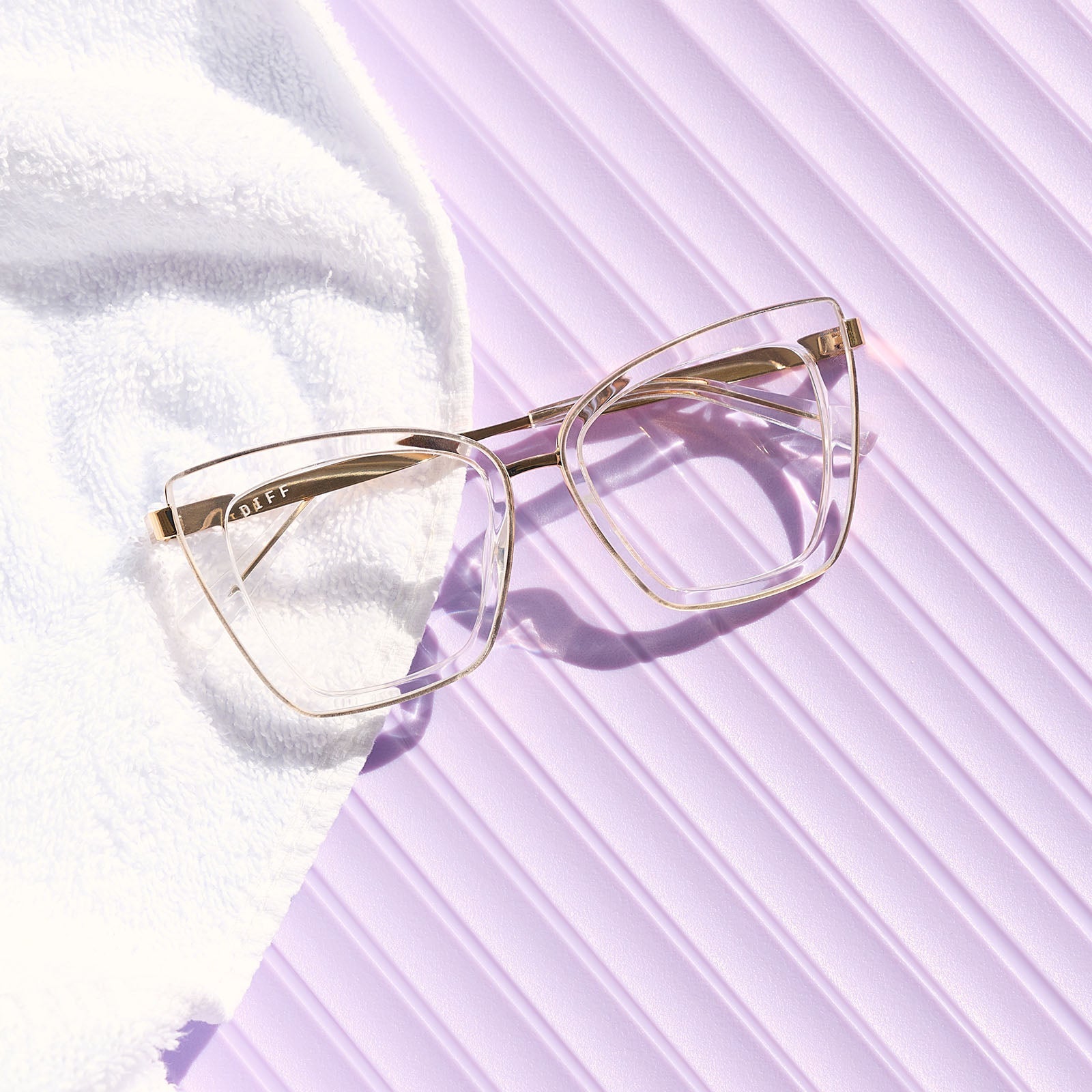 still life of diff eyewear the becky iv cat eye prescription glasses with a clear crystal with gold frame front view