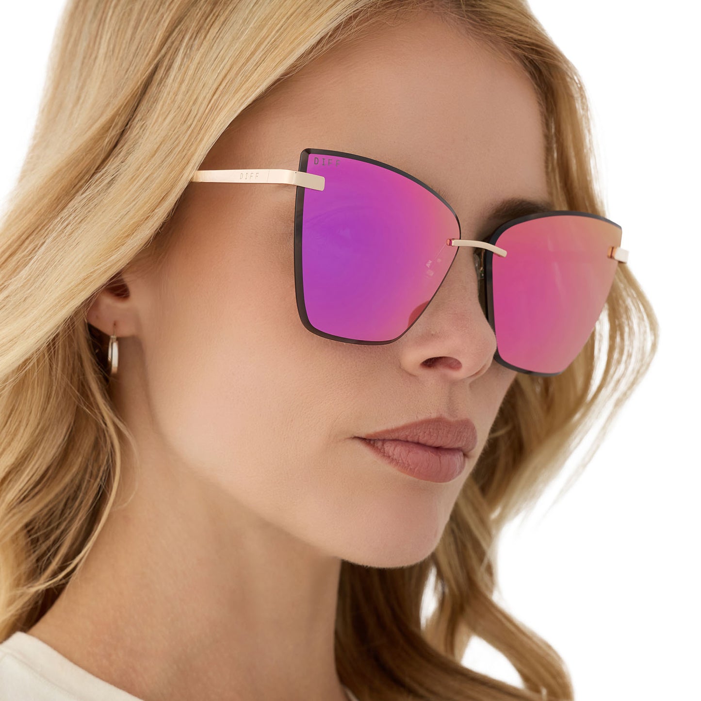 on model - female wearing diff eyewear featuring the becky v cat eye sunglasses with a gold frame and pink rush mirror lenses angled view